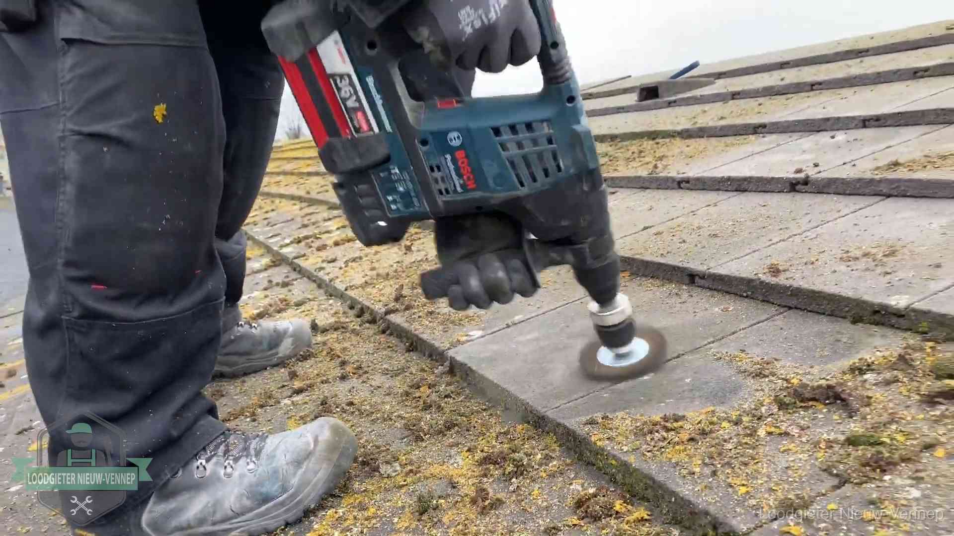Betonnen dakpannen worden machinaal gereinigd tijdens dakonderhoud in Nieuw-Vennep