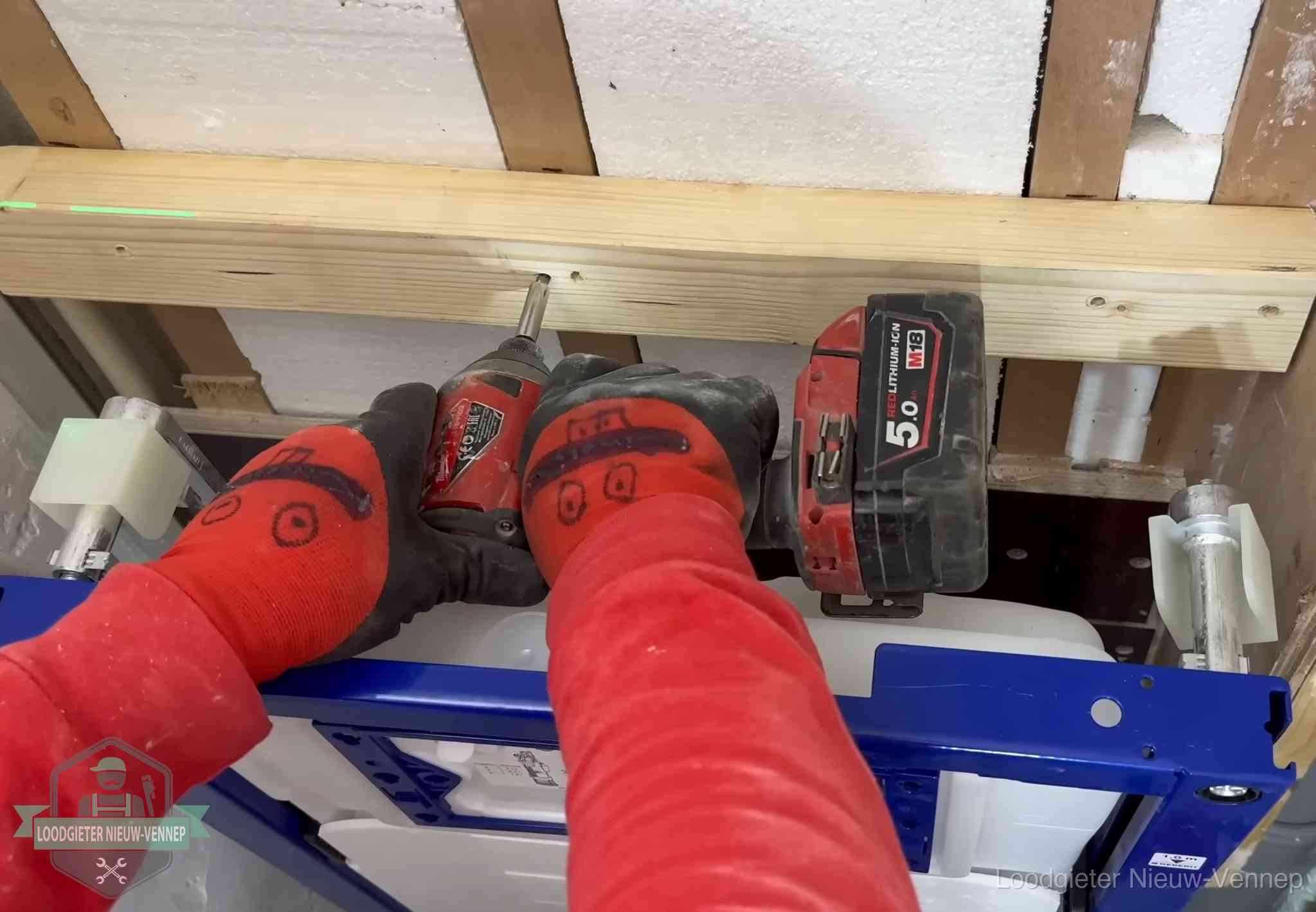 Monteur bevestigt een inbouwreservoir voor een hangend toilet in Nieuw-Vennep