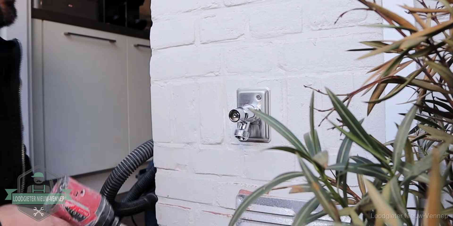 Chromen kraan op een muurplaat bij een woning in Nieuw-Vennep, dichtdraaien is stap een van de lektest