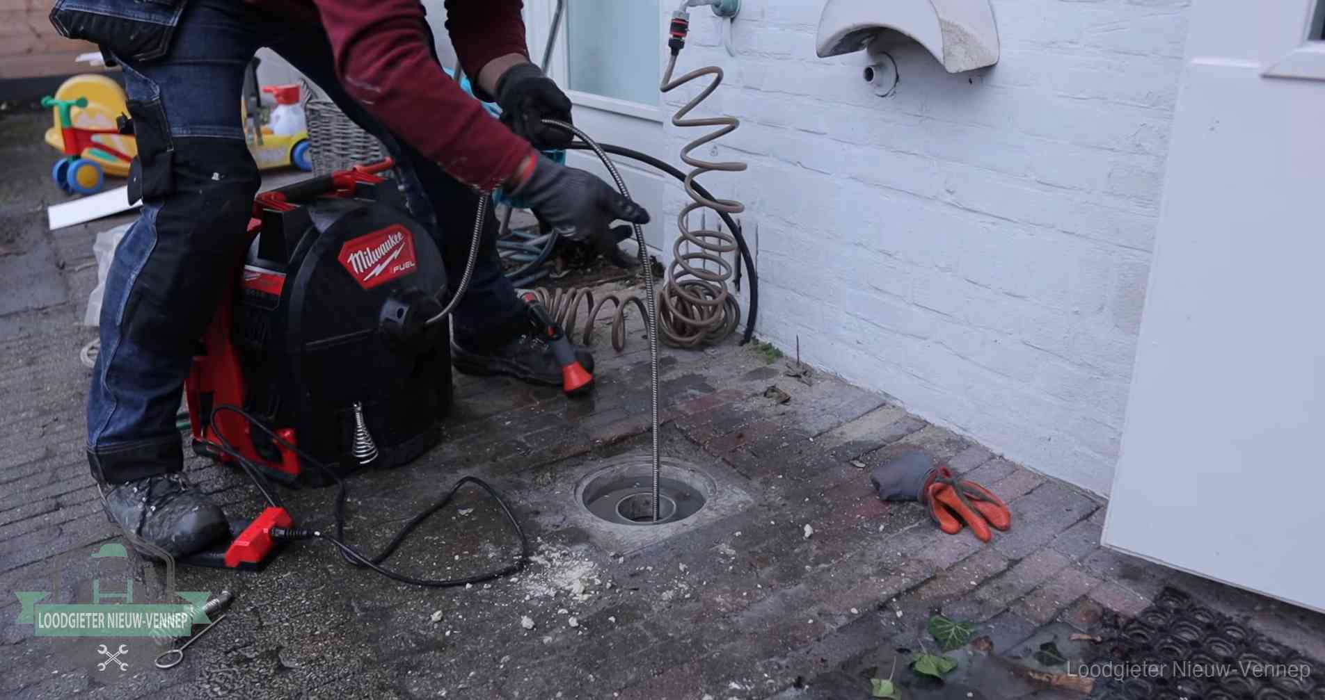 Erfgrens en gemeenteriool in Nieuw-Vennep Ontstoppingsputje in de bestrating naast de gevel van een woning in Nieuw-Vennep