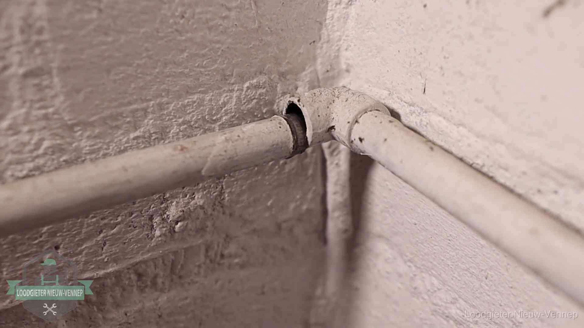 Oude geverfde waterleiding met een losliggende fitting in een woning in Nieuw-Vennep