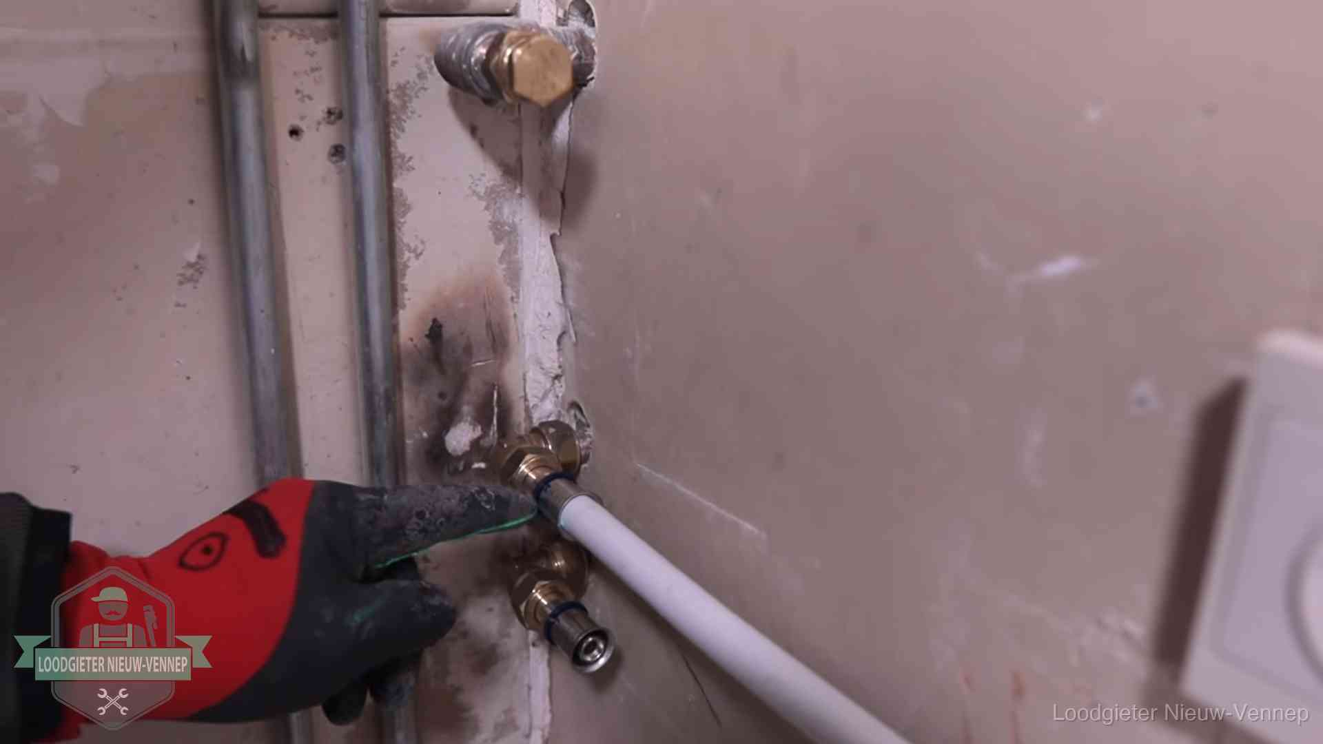 Garantie op loodgieterswerk in Nieuw-Vennep Loodgieter wijst de persfitting op nieuwe muuraansluitingen aan in een woning in Nieuw-Vennep