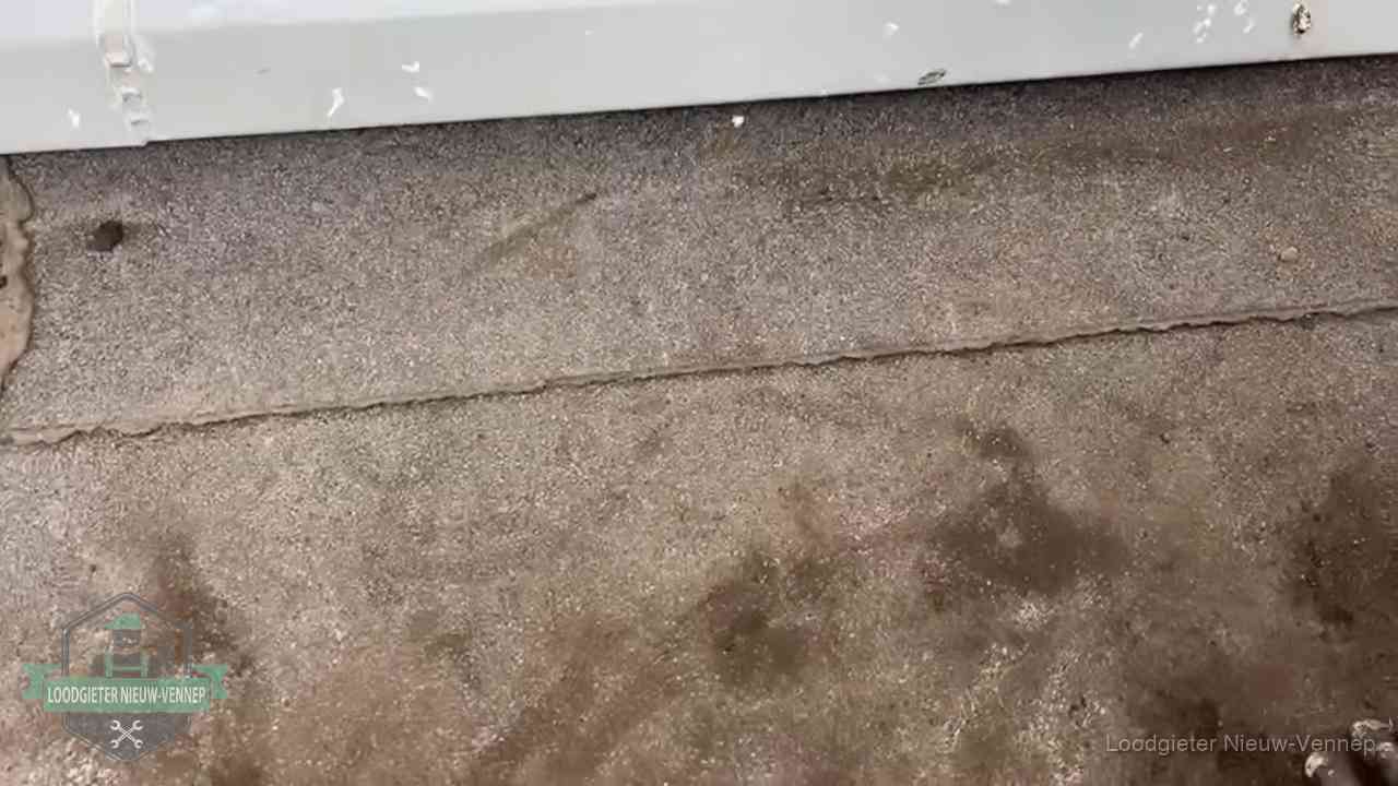 Vochtplekken bij de naad van een plat dak na aanhoudende regen in Nieuw-Vennep