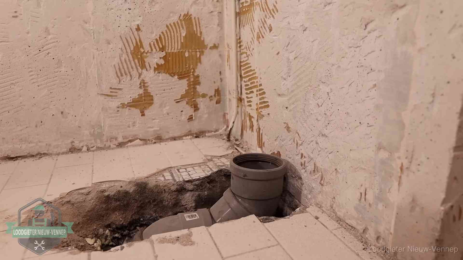 Verzakt riool herstellen in Nieuw-Vennep Opengebroken vloer met een nieuwe pvc-rioolbocht in een gegraven sleuf in Nieuw-Vennep