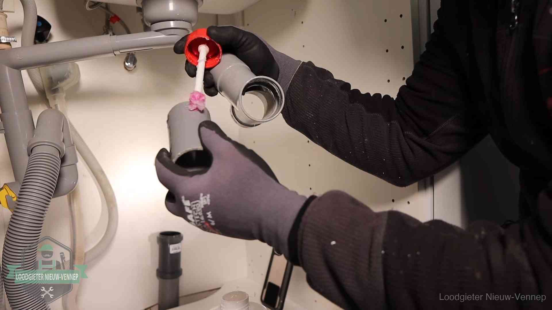 Oorzaak van een verstopte afvoer in Nieuw-Vennep Loodgieter demonteert en reinigt de sifon onder een keukenkast in Nieuw-Vennep