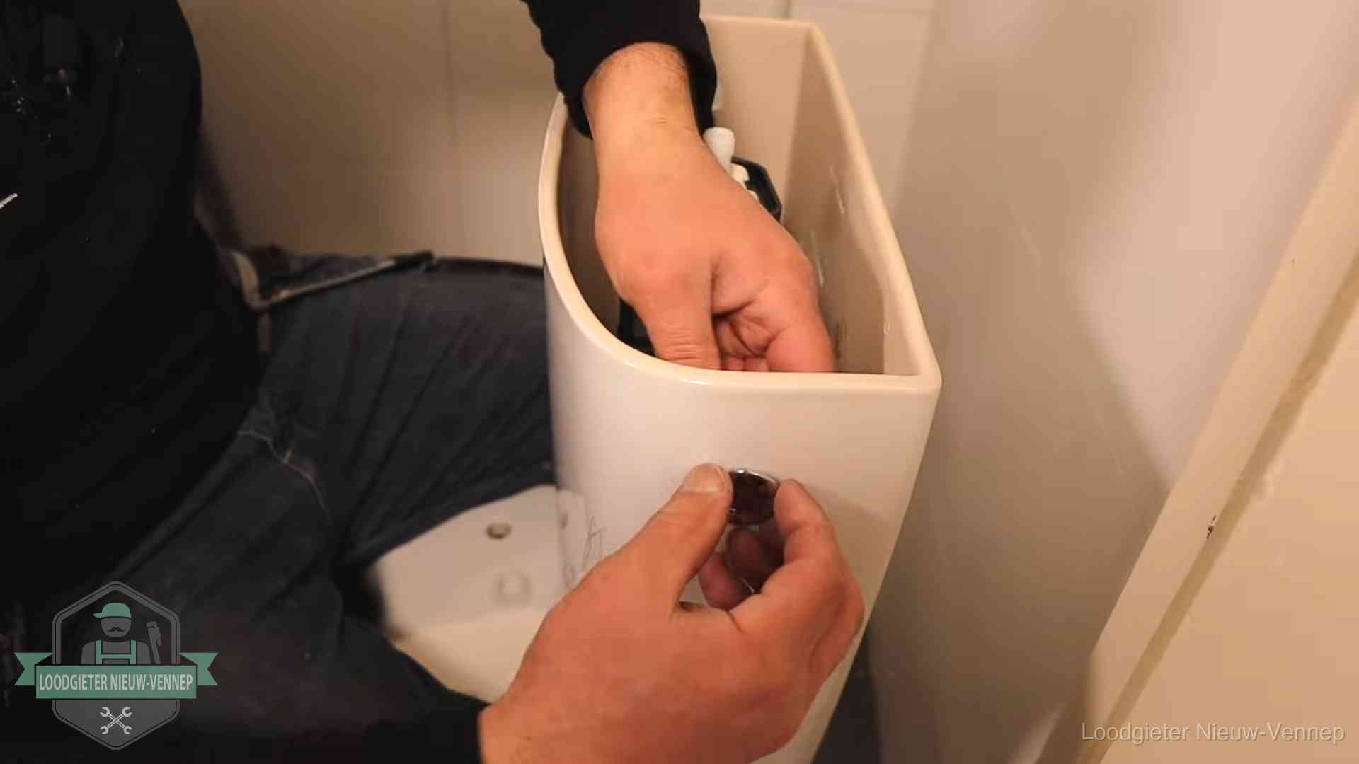 Drukknop van een duoblok-stortbak wordt gemonteerd bij een toilet in Nieuw-Vennep
