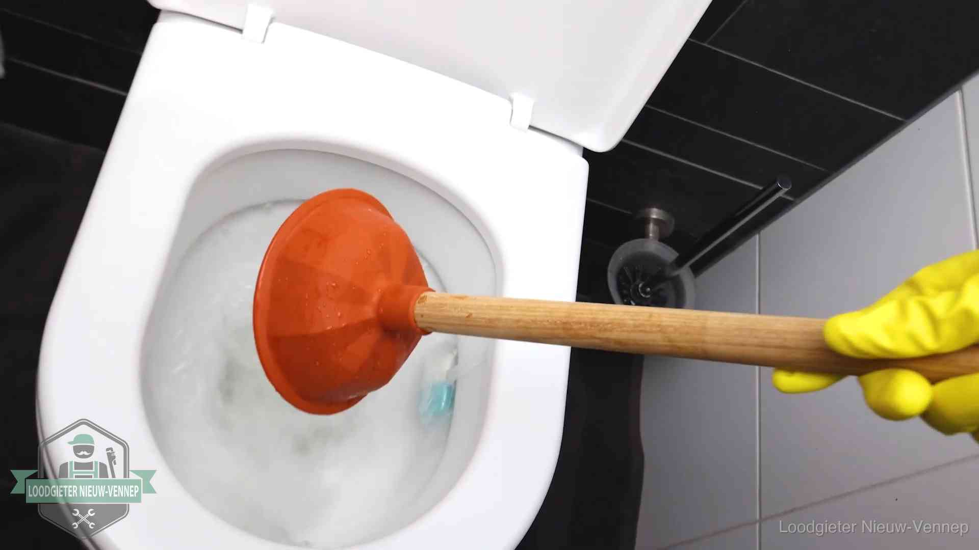 Plopper wordt in de wc-pot gedrukt bij het ontstoppen van een toilet in Nieuw-Vennep