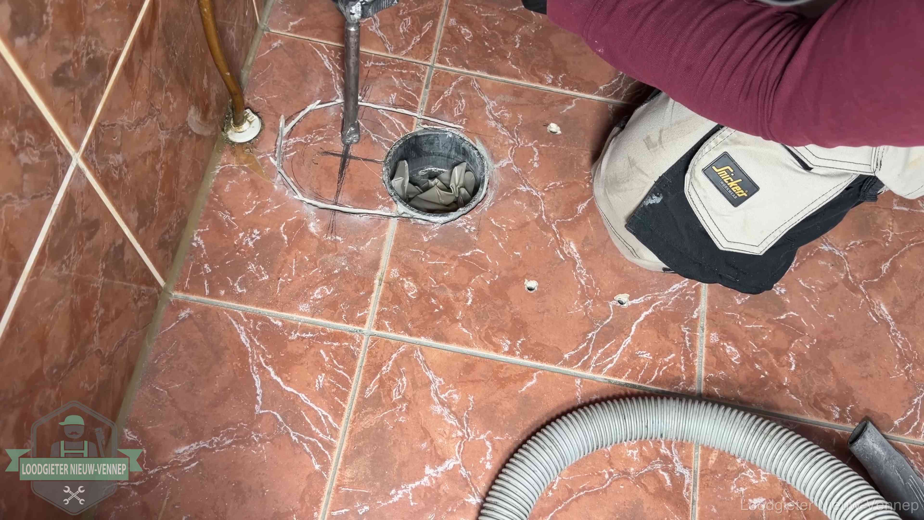 Open rioolaansluiting in de vloer waar de wc-pot is gedemonteerd in Nieuw-Vennep
