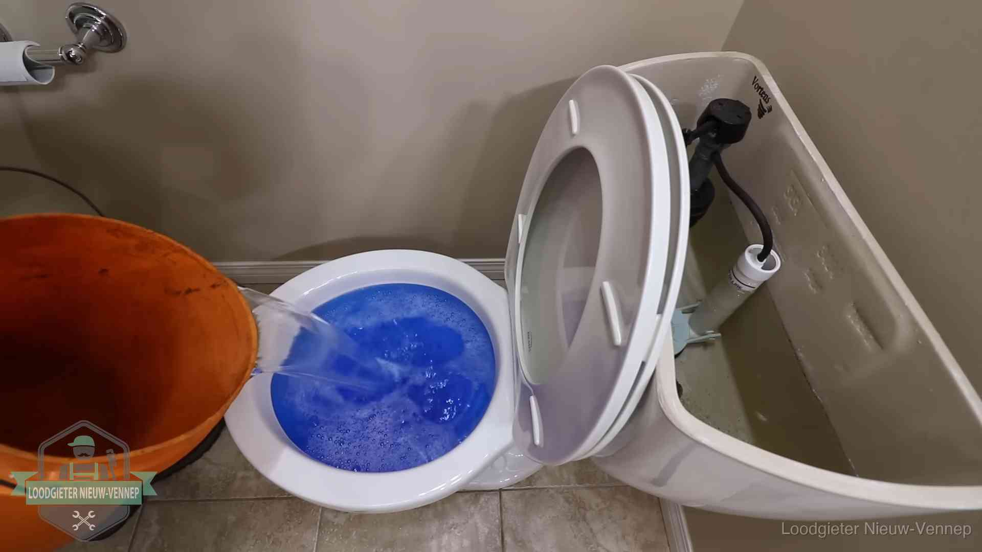 Water bij de wc-pot wordt met een emmer weggewerkt om schade te beperken in Nieuw-Vennep